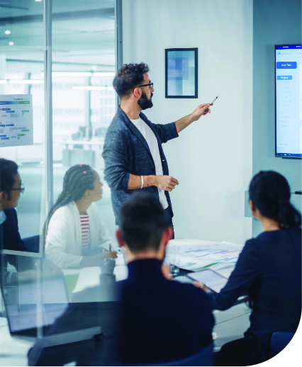 People around a meeting table with a smart board
